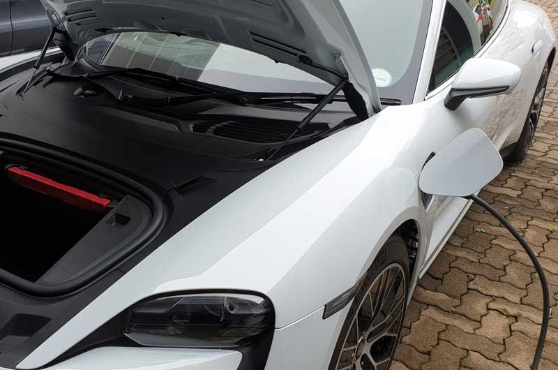 Charging-a-white-Porsche-Taycan-with-open-Frunk