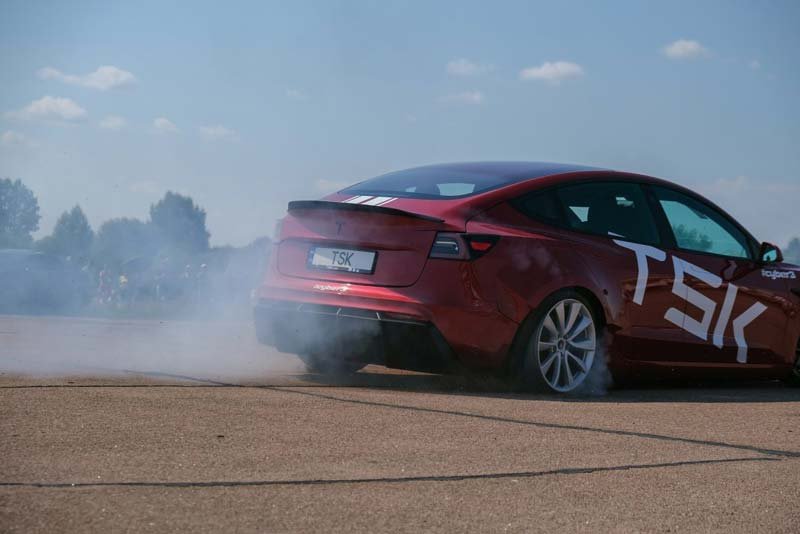 tesla-electric-car-on-shingles-makes-figures-e-drive-electric-vehicle-drives-red-car-spins-in-a-circle